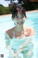 A woman in a white bikini in a swimming pool.