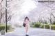 A woman in a white bikini standing in the middle of a road.