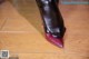 A close up of a woman's shoes on a wooden floor.