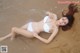 A woman in a white bikini laying on the beach.