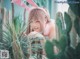 A woman in a bunny costume leaning against a cactus.