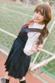 A woman in a school uniform posing for a picture.