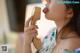 A woman is licking a telephone receiver with her tongue.