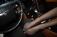 A woman's feet on the steering wheel of a car.