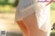 A close up of a person wearing a white skirt.