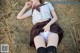 A woman in a school uniform laying on a pile of hay.