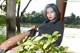 A woman sitting on a bench next to a tree.