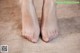 A close up of a person's bare feet on a carpet.